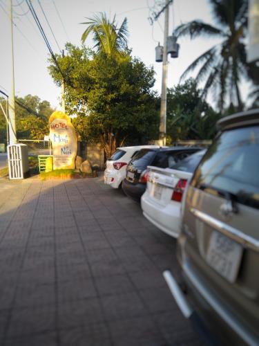 a row of parked cars parked next to a sidewalk at Minh Nhi Hotel in La Gi