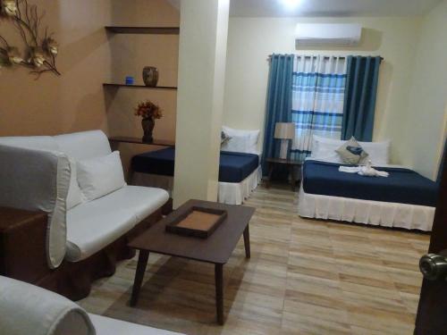 a living room with two beds and a couch at Charos Dormitel in Dumaguete