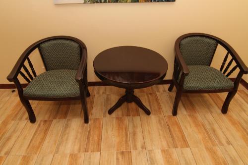 two chairs and a table and a table and two chairs at Charos Dormitel in Dumaguete