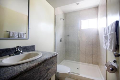 a bathroom with a sink and a toilet and a shower at Hotel Astor Tijuana in Tijuana