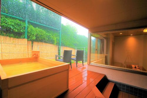 een kamer met een groot raam en een bad bij Hakone Hoshi no Akari in Hakone