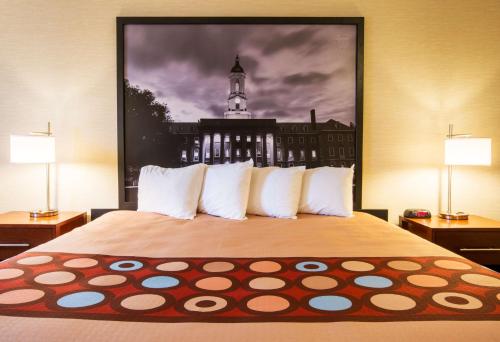a bedroom with a bed with a large picture on the wall at Super 8 by Wyndham State College in State College