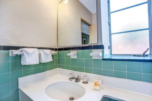 y baño con lavabo y espejo. en Days Inn by Wyndham Arlington/Washington DC, en Arlington
