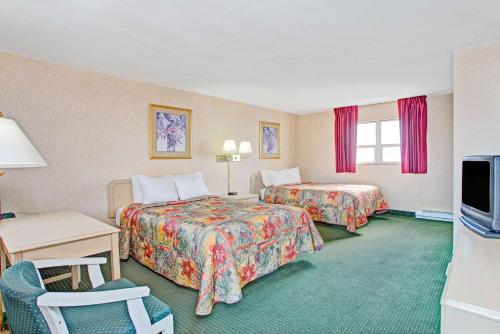 a hotel room with two beds and a television at Days Inn by Wyndham Arlington/Washington DC in Arlington