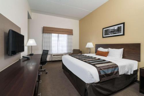 a hotel room with a large bed and a flat screen tv at Wingate by Wyndham Bowling Green in Bowling Green