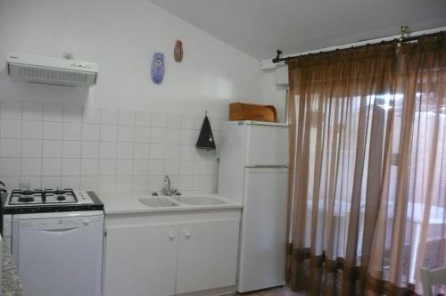 a small kitchen with a sink and a stove and a sink at 15mn de Cannes, Villa la Soleiade , Gite ,Lodge , type T2, clim, piscine, parking au Lac de Saint-Cassien VAR in Montauroux