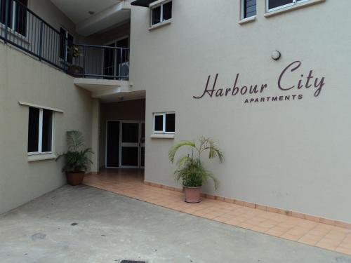 a white building with a sign that reads harrow city architects at Inner city Cardona Court apartment in Darwin
