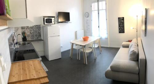 a kitchen and a living room with a couch and a table at Maison Bernadette - Rez-de-chaussée in Vitry-sur-Seine