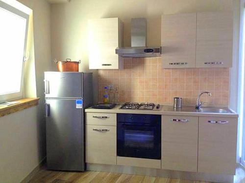 a kitchen with a stainless steel refrigerator and a sink at La Giazzera in Dervio