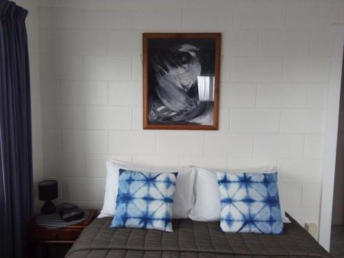 a bedroom with a bed with a picture on the wall at Redwood Lodge Motel in Levin