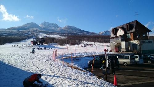 a group of people playing in the snow at Lodge Amenouo in Myoko