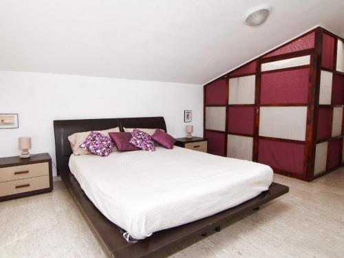 ミラッツォにあるIl Covo sul portoのベッドルーム(紫色の枕が付いた大きな白いベッド付)