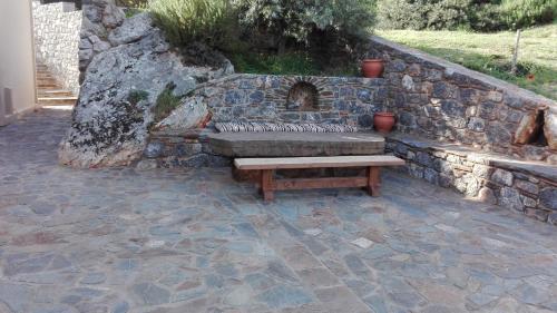 a stone wall with a bench in a patio at Villa Cazala in Monemvasia