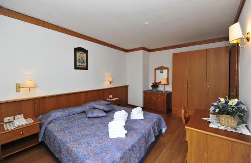 a bedroom with a bed with towels on it at Ski Residence in San Martino di Castrozza