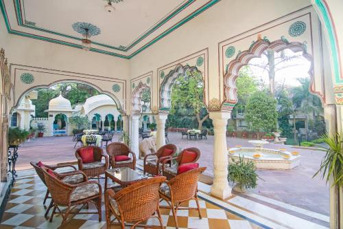 a room with chairs and tables and a courtyard at Alsisar Haveli - Heritage Hotel in Jaipur