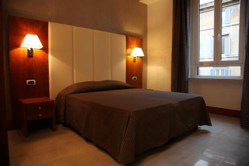 ローマにあるFEDERICA'S APARTMENT IN ROMEのベッドルーム1室(ベッド1台、壁に照明2つ付)