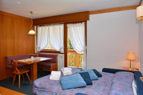 a bedroom with a bed and a desk and a table at Ski Residence in San Martino di Castrozza