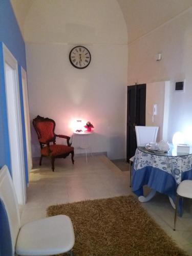 a living room with a table and a clock on the wall at Il Da Vinci casa vacanze in Giovinazzo