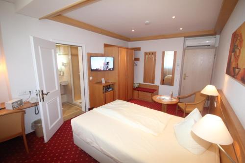 a hotel room with a bed and a bathroom at Wohlfühlhotel Bercher in Waldshut-Tiengen