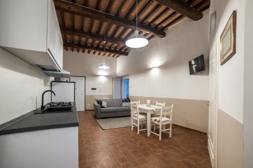 a kitchen and a living room with a table and chairs at La dimora nel Castello in Collevalenza