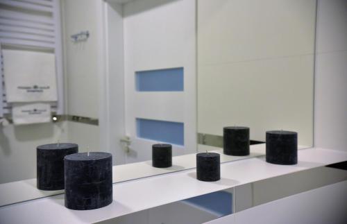 a bathroom with four black objects on a counter at Apartamenty Platan Opieszyn 2 in Września
