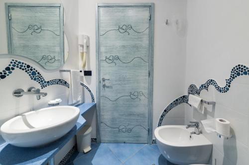 un bagno blu e bianco con lavandino e doccia di Parco Residence La Rosa a Ischia