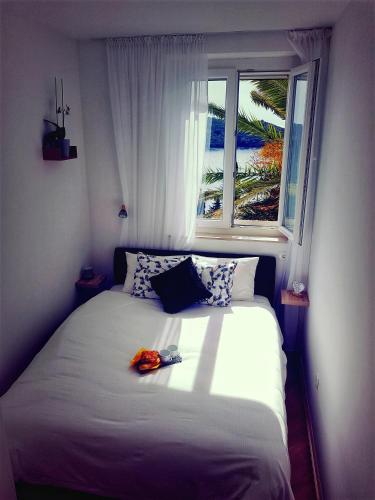 a bedroom with a white bed with a window at SoLeo in Dubrovnik