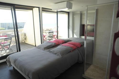 a bedroom with a large bed with red pillows on it at Studio Naturiste Gamme Luxe in Cap d'Agde