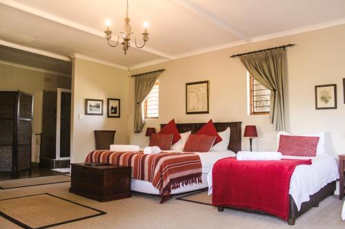 a bedroom with two beds and a chandelier at Gerald's Gift Guest House in Addo