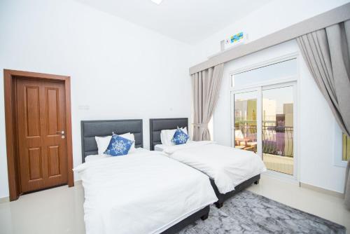 2 camas en una habitación con ventana en Bedyiah Green Homes en Al Qābil