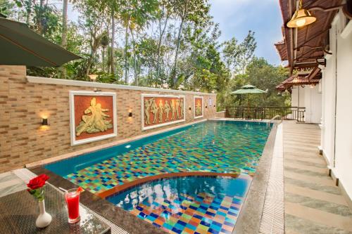 a swimming pool with colorful tile in a house at Crown Valley Thekkady in Thekkady