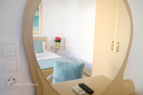 a mirror in a room with a bed and remote controls at River Side Hotel in Georgioupolis