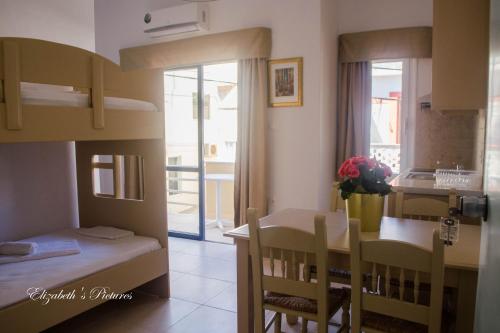 a small room with a bed and a table and a kitchen at River Side in Georgioupolis