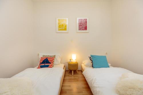 deux lits jumeaux dans une chambre aux murs blancs dans l'établissement Two bedroom Sunny Suite, à Dubrovnik
