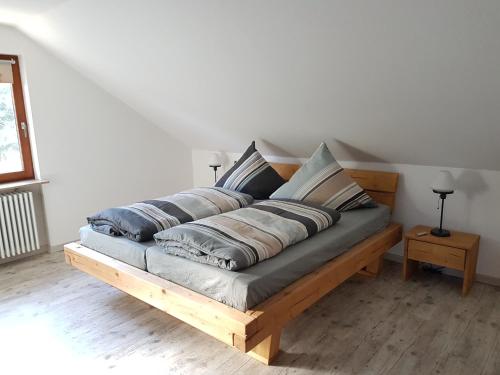 a wooden bed with pillows on it in a room at Haus Bella in Löffingen