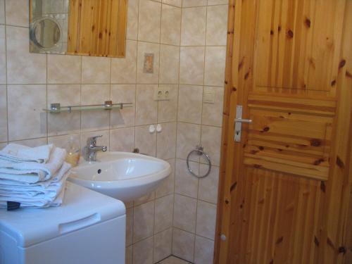 uma casa de banho com um lavatório branco e um espelho. em Ferienhaus Troge em Zinnowitz