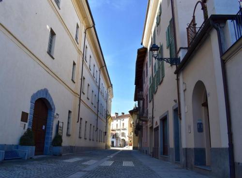 an empty street in a town with white buildings at Casa Al convento in Savigliano