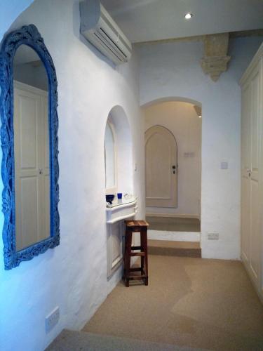 a bathroom with a mirror and a stool in a room at St. Agatha's Bastion in Mdina