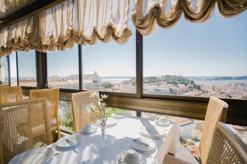 a dining room with a table and views of the city at Albergaria Senhora do Monte in Lisbon