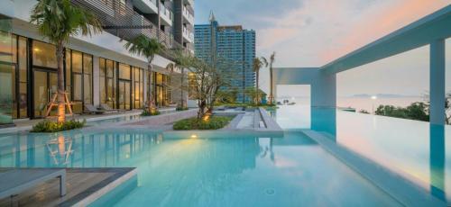 a swimming pool in the middle of a building at Kuno - 2Br, Beachfront Jomtien in Jomtien Beach