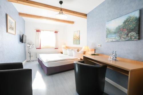 Cette chambre comprend un lit et un bureau. dans l'établissement Hotel Bützower Hof, à Bützow