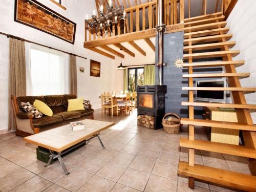 a living room with a staircase and a couch and a table at Holiday home in peaceful setting and large garden in Rendeux