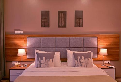 a bedroom with a large bed with two lamps at Veli Vilaa in Dhiffushi