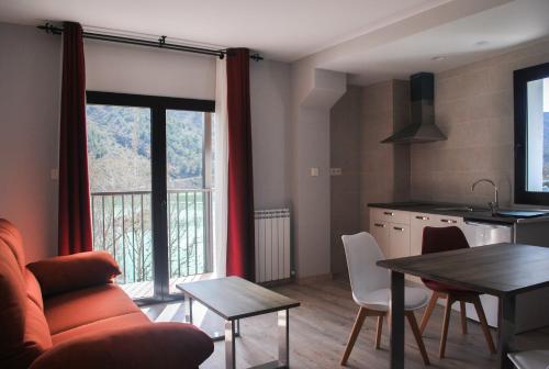 a living room with a couch and a table and a kitchen at El Capricho de Arguis in Arguis