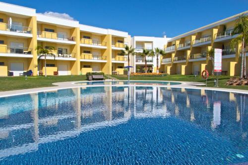a large swimming pool in front of a hotel at Apartamento O Jardins da Marina in Albufeira