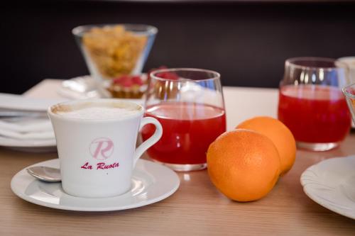 Una taza de café y dos naranjas en una mesa. en La Ruota, en Morbegno