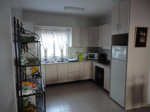 a kitchen with white cabinets and a white refrigerator at Comodidad en AGUAMARGA! in Agua Amarga