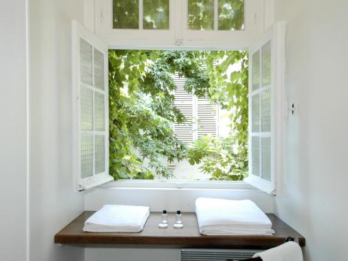 une fenêtre avec deux serviettes sur un banc devant elle dans l'établissement Mithouard Apartments, à Paris