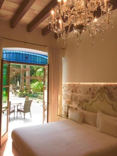 a bedroom with a large bed and a chandelier at Finca Cas Sant in Sóller