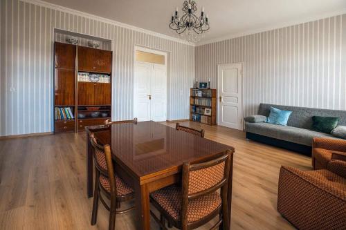 een woonkamer met een houten tafel en een bank bij Gogi Dvalishvili Wine Cellar in Gori